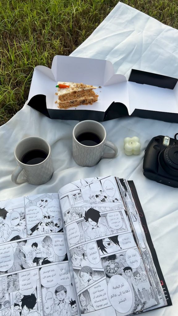 A picnic with a book and coffee on a blanket