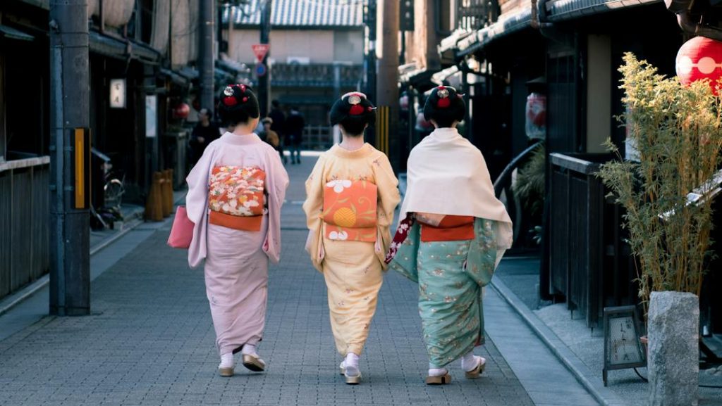 Three Woman Wearing Traditional Dresses Walking On Street