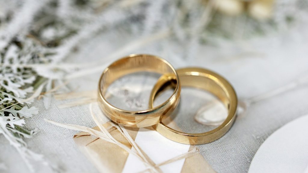 gold wedding band on white textile