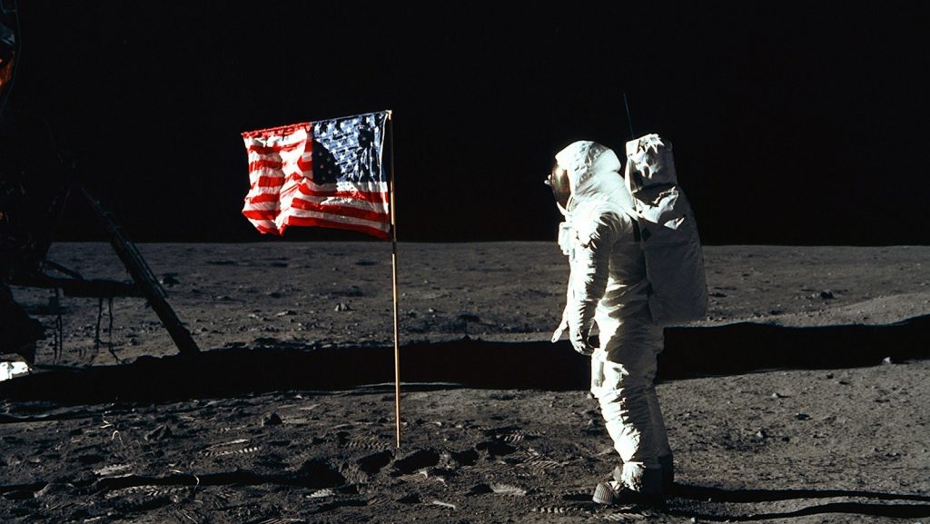 Buzz Aldrin on the moon in front of the US flag